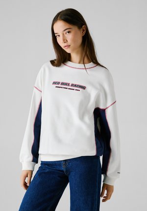 Felpa bianca con accenti rossi e blu navy, con la scritta "Red Bull Racing". Materiale morbido, vestibilità comoda, polsini e collo a coste.