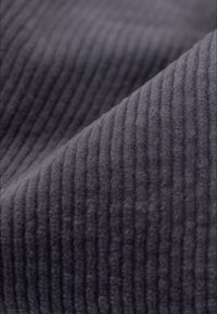 Szary prążkowany materiał o miękkiej, teksturowanej powierzchni, z wyraźnymi pionowymi liniami i gładkim, puszystym wykończeniem.