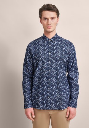 Navy floral shirt with small blue and white patterns, button-up design, long sleeves, and a classic collar. Soft fabric texture.