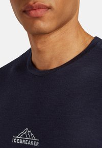 T-shirt a girocollo blu navy realizzato in tessuto morbido, con un logo bianco di montagna nella zona sinistra del petto.