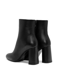 Bottes noires en cuir à chevilles avec une texture lisse, bout arrondi et talons larges en bloc. Dotées d'une fermeture éclair à l'arrière.