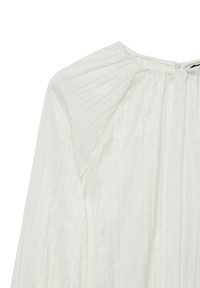 Blusa bianca plissettata con scollatura rotonda e zip invisibile. Realizzata in tessuto leggero e texturizzato con una morbida e sottile lucentezza.