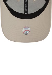 Barna szövetből készült baseball sapka fekete karimával. Kerek matricával rendelkezik, amelyen egy baseball grafika és piros varrási részletek találhatóak.