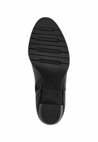 Semelle de chaussures en cuir noir avec des rainures horizontales surélevées pour une meilleure traction et un bout lisse et arrondi. Logo embossé près du talon.