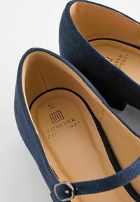 Chaussures Mary Jane en daim bleu marine avec bouts arrondis, semelles intérieures beiges marquées "Forever Comfort", taille 6½/40, et brides à boucle argentée.