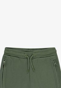 Groene katoen sweatpants met een trekkoornauwkeurigheid, geribbelde textuur en twee ritszakken aan de zijkant.