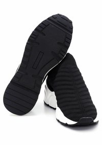 Black knit slip-on sneaker with white textured sole, one shoe showing top and the other showing black rubber tread bottom.