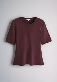 Top burgundy tricotat cu mâneci scurte și decolteu rotund atârnat pe un fundal simplu, gri deschis.