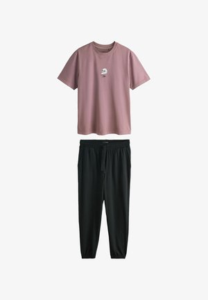 Világos rózsaszín pamut póló kis grafikával, fekete, finom anyagból készült, megkötős futónadrággal párosítva. Mindkettő laza fazonú.