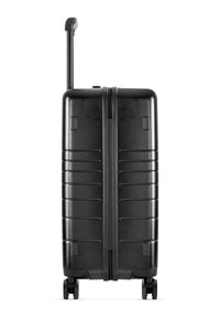 Black hard-shell suitcase with horizontal grooves, extendable handle, four wheels, and zipper closure. Smooth, shiny surface. Compact design.