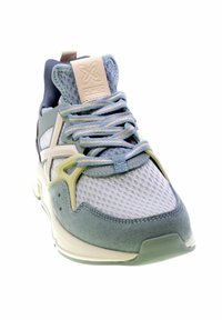 Zapatilla deportiva en azul claro y gris con tejido de malla, cuello acolchado y diseño de cordones texturizado. Presenta un acento verde en contraste en el costado.