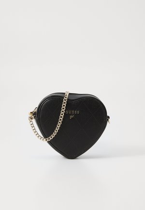 Bolso cruzado Guess en forma de corazón negro con patrón acolchado y correa de cadena dorada, exhibido sobre fondo blanco.