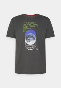 T-shirt en coton gris avec un logo NASA vert, des graphiques circulaires bleus et un design de globe blanc. Col rond avec des manches courtes.