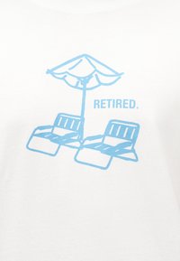 Δύο μπλε ανακλινόμενες καρέκλες κάτω από μια παραλιακή ομπρέλα με τη λέξη «ΣΥΝΤΑΞΙΟΥΧΟΣ» σε ανοιχτό μπλε χρώμα σε λευκό φόντο.