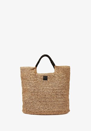 Borsa tote intrecciata color cuoio con manico nero avvolto e una piccola toppa nera davanti, su sfondo bianco.