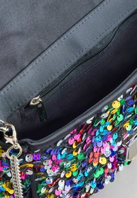 Svart väska med färgglada paljetter, med ett innerfack med dragkedja, slät tygfoder och silverfärgade detaljer.