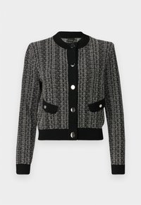 Svart- och vitrandig stickad cardigan med långa ärmar, ribbade muddar och fåll. Har två framfickor och stora metallknappar.