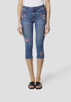 Modre denim kratke hlače s cvetličnim vezenjem na nogah, z obliko s petimi žepi in oprijetim krojem, ki se končajo tik pod kolenom.