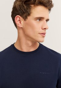 Granatowa bawełniana koszulka z okrągłym dekoltem, z subtelnym logo "bugatti" na piersi i gładką, miękką teksturą.