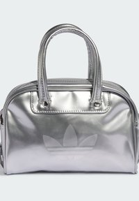 Srebrna metaliczna torebka z podwójnymi uchwytami, gładką fakturą, zapięciem na zamek oraz subtelnym wytłoczonym logo z przodu. Kompaktowy design.
