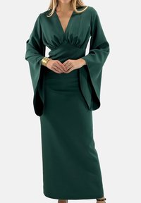 Długa zielona sukienka z satyny z głębokim dekoltem w serek, marszczonym gorsetem i szerokimi rozkloszowanymi rękawami. Gładka faktura; długość do ziemi z dopasowanym fasonem.