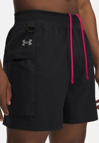 Schwarze Badeshorts aus leichtem Material, mit einer pinken Kordel und weißen Akzenten sowie einer Seitentasche mit Logo.