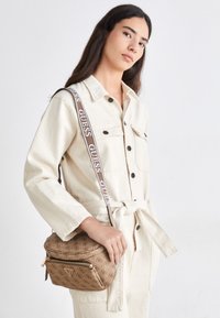 POWER PLAY MINI SLING - Geantă crossbody - latte logo