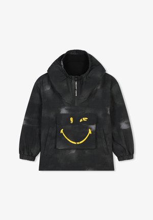 Giacca nera tie-dye con cappuccio, dotata di un sorriso giallo sul taschino anteriore, polsini elasticizzati e apertura con zip sul collo.