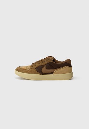 Low-Top Nike Sneaker aus braunem und beigem Wildleder mit Schnürverschluss und beiger Gummisohle, seitlich auf einfarbigem Hintergrund dargestellt.