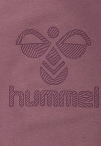 Bordowy materiał z ciemnofioletowym, geometrycznym wzorem pszczoły nad słowem "hummel", z paskowym detalem dla uzyskania tekstury.