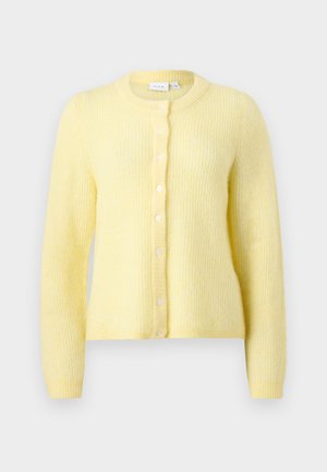 Μαλακό κίτρινο πλεκτό ζακέτα με μακριά μανίκια, στρογγυλή λαιμόκοψη και κούμπωμα μπροστά με οκτώ λευκά κουμπιά.