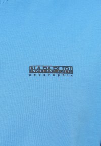 Ανοιχτό μπλε κοντομάνικο T-shirt από μαλακό βαμβάκι, με μαύρο εκτυπωμένο λογότυπο στο εμπρόσθιο μέρος και το κείμενο "NAPAPIJRI geographic."