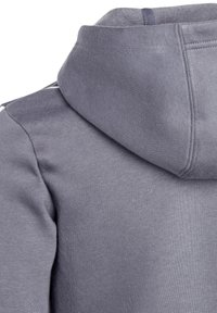 Hoodie gris en tissu polaire texturé, avec une capuche à cordon de serrage et des coutures superposées sur les épaules. Design simple sans motifs.