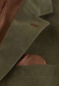 Revers de blazer à carreaux verts avec pochette en soie marron à motif et doublure intérieure assortie détaillée d'un motif floral.