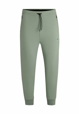 Light green jogger pants made from soft fabric, featuring an adjustable waistband, two side pockets, and ribbed cuffs at the ankles.