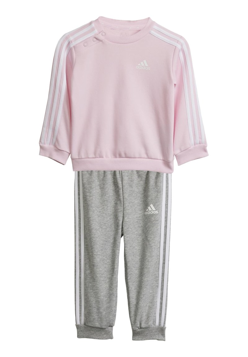 Felpa rosa con strisce bianche e bottoni a pressione, abbinata a pantaloni felpati grigi con strisce laterali bianche e logo. Tessuto morbido.