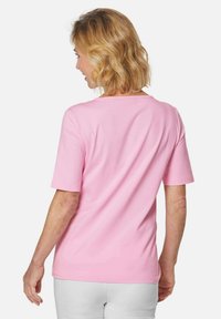 Rosa T-Shirt mit kurzen Ärmeln aus weichem Baumwollstoff, ausgestattet mit einem klassischen Rundhalsausschnitt und einem lockeren Schnitt für optimalen Komfort.