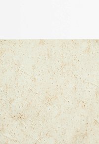 Surface en marbre beige avec des veines et des taches marron et gris clair, montrant la texture et le motif naturel de la pierre.