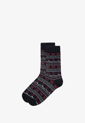 Schwarze Socken mit einem wiederholten Muster aus roten Schneeflocken, geometrischen Formen und weißen Akzenten. Aus gestricktem Stoff mit einem gerippten Bündchen gefertigt.