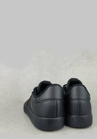 Czarne skórzane sneakersy o gładkiej teksturze, zaokrąglonym kształcie i wyściełanym kołnierzem. Posiadają trzy boczne paski oraz logo z tyłu.