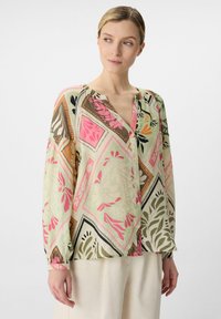 Wielokolorowa, lekka bluzka z geometrycznym i kwiatowym wzorem w odcieniach różu, zieleni i brązu. Posiada zapięcie na guziki z przodu oraz długie rękawy.
