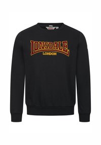 Sudadera negra de algodón, con cuello redondo y mangas largas. En el frente muestra "LONSDALE LONDON" en texto amarillo y burdeos.