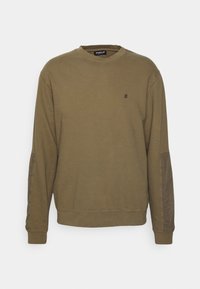 Olivgrön sweatshirt med rund hals, långa ärmar och en liten broderad logotyp på bröstet. Har texturerat tyg på ärmarna.