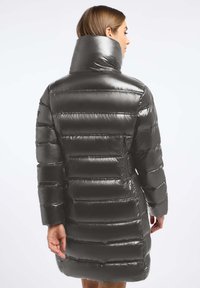 Grijze pufferjack met een glanzende afwerking, verticale gestikte textuur, hoge kraag en lengte tot midden boven de dij, met lange mouwen en zijzakken.