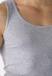 Szary bawełniany top bez rękawów z okrągłym dekoltem, o gładkiej fakturze i subtelnym melanżowym wzorze.