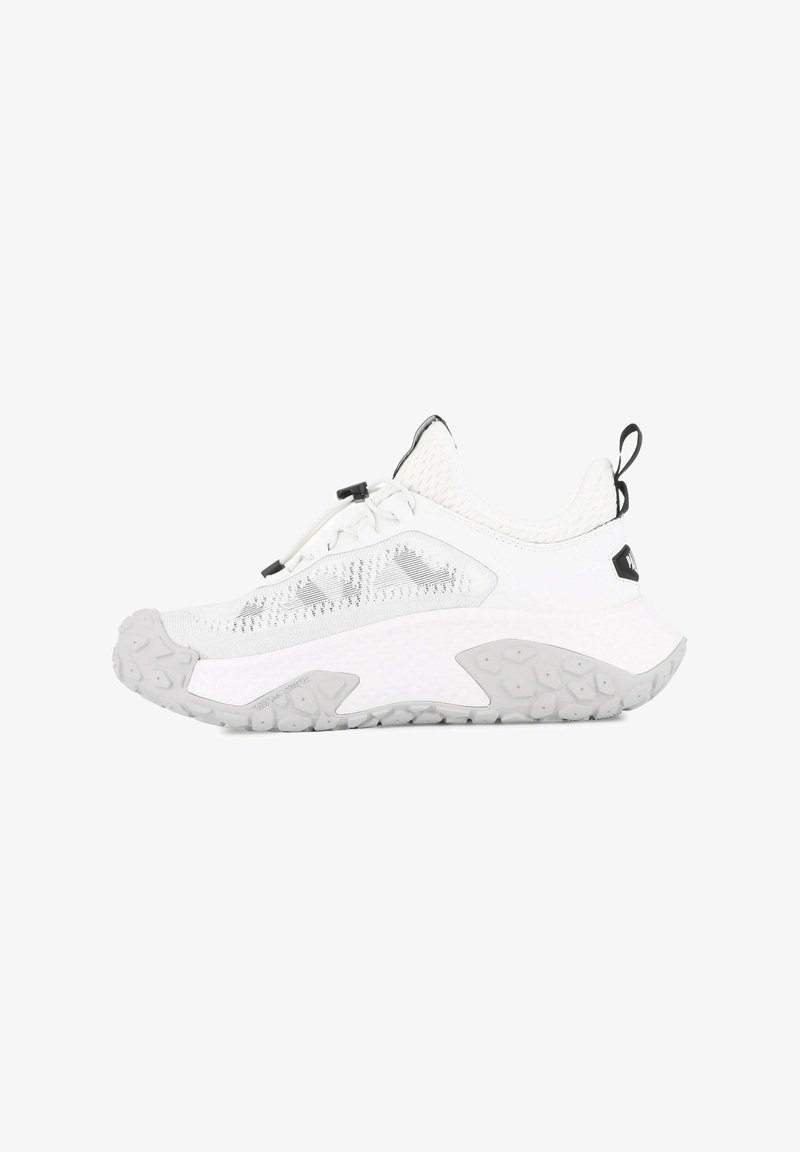 Basket blanc avec une tige en maille texturée, un design flexible, une semelle en caoutchouc gris épais et un accent noir près du talon.