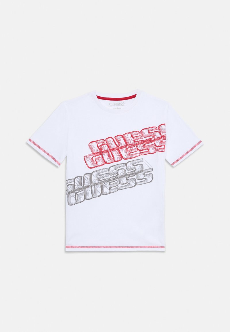 T-shirt en coton blanc présentant un design de texte entrelacé "GUESS" en rouge et gris. Manches courtes avec des coutures rouges au niveau de l'encolure et des bras.