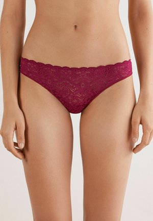 Bordeaux kanten string met golvende randen, voorzien van ingewikkelde bloempatronen en een semi-doorzichtige textuur. Ontworpen voor comfort en stijl.