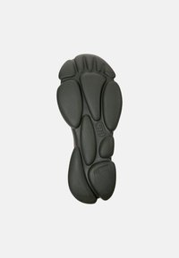 Suola di scarpa in gomma nera con cuscinetti arrotondati e strutturati e una sezione centrale prominente, progettata per trazione e comfort.