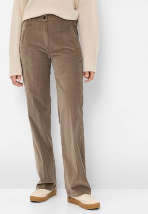 Bruine corduroybroek met rechte pijpen, voorzien van een ontwerp voor een voorzak, knoopsluiting en een zachte textuur. Gedragen met een beige trui en schoenen.